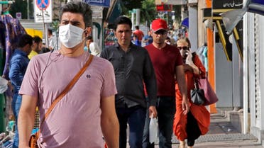 Iranians, some wearing face masks, walk along a street in the capital Tehran on June 3, 2020. (AFP)