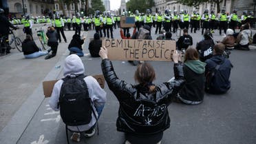 Protesters sit down in the road in Whitehall in front of lines of police officers in central London after a demonstration, on June 7, 2020, organised to show solidarity with the Black Lives Matter movement in the wake of the killing of George Floyd, an unarmed black man who died after a police officer knelt on his neck in Minneapolis. Taking a knee, banging drums and ignoring social distancing measures, outraged protesters from Sydney to London on Saturday kicked off a weekend of global rallies against racism and police brutality.