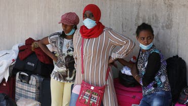 Ethiopian domestic workers wearing masks gather with belongings in front of the Ethiopian consulate in Hazmiyeh, Lebanon, June 8, 2020. (Reuters)