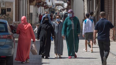 Pedestrians, wearing protective masks due to the COVID-19 pandemic, walk past closed shops in the Moroccan capital Rabat on June 10, 2020, as the government declared the extension of coronavirus lockdown until July 10. (AFP)