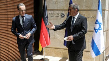 German Foreign Minister Heiko Maas and his Israeli counterpart Gabi Ashkenazi hand each other documents during their news conference in Jerusalem June 10, 2020. REUTERS/Ronen Zvulun