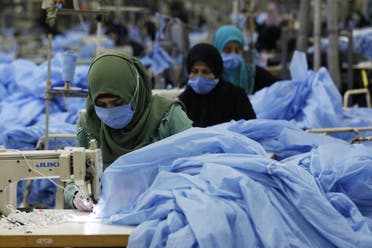 Women sew protective suits, following the outbreak of the coronavirus disease (COVID-19), at a factory in the holy city of Najaf, Iraq June 10, 2020. (Reuters)