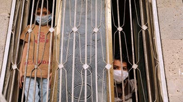 Children wearing protective masks look from behind a window during a 24-hour curfew amid concerns about the spread of the coronavirus disease (COVID-19), in Sanaa. (File photo: Reuters)