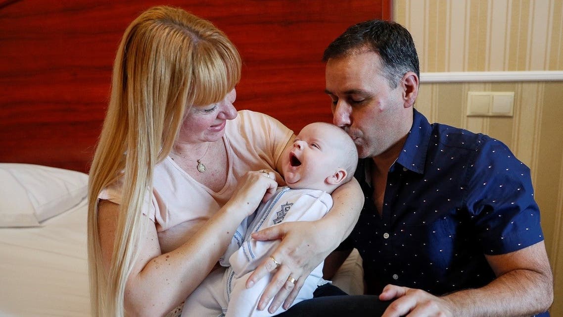 Jose Perez and Flavia Lavorino from Buenos Aires react during the first meeting with their son Manuel, who was born to a surrogate mother in a Ukrainian BioTexCom clinic in Kiev, Ukraine June 10, 2020. (Reuters)