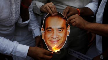 Activists of the youth wing of India's main opposition Congress party burn a cut-out with an image of billionaire jeweller Nirav Modi during a protest in Mumbai. (Reuters)