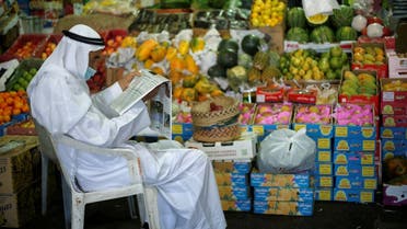 A Bahraini vendor, wearing a face mask, following the outbreak of the coronavirus disease (COVID-19), reads a newspaper as he waits for customers at his fruits stand, in Central Market, in Manama, Bahrain, June 13, 2020. (Reuters)