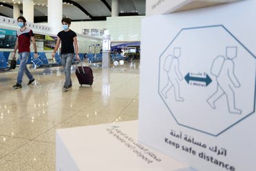Travelers wearing protective face masks walk at Riyadh International Airport. (File photo: Reuters)