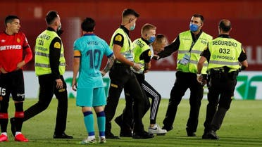 A pitch invader is apprehended by stewards, as play resumes behind closed doors following the outbreak of the coronavirus disease. (Reuters)
