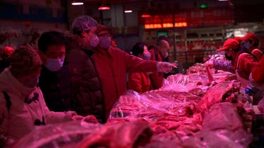 Customers wearing face masks buy pork meat at the Xinfadi wholesale market, as the country is hit by an outbreak of the novel coronavirus disease (COVID-19), in Beijing. (Reuters)