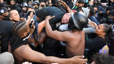 A man is lifted up and taken to police lines after being beaten in clashes between protesters supporting the Black Lives Matter movement and opponents in central London on June 13, 2020. (AFP)