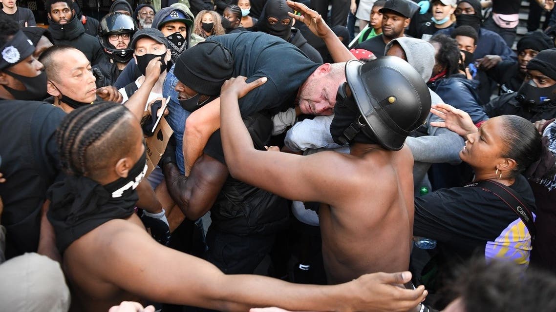 A man is lifted up and taken to police lines after being beaten in clashes between protesters supporting the Black Lives Matter movement and opponents in central London on June 13, 2020. (AFP)