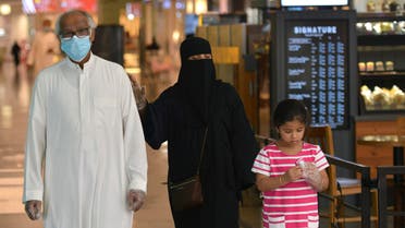 Saudi Arabian couple with child at the mall in Riyadh, June 4, 2020. (AFP)