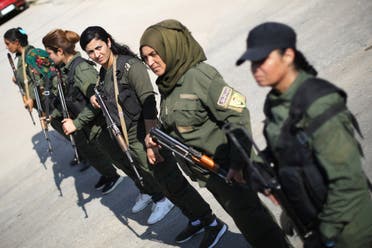 Kurdish policewomen stand guard as Kurdish and Arab protesters take part in a march against Turkish President and walk to the United Nations Headquarters in the town of Qamishli, Syria October 23, 2019. (Reuters) 