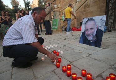 A man places a candle during a vigil in solidarity with Italian Jesuit priest Father Paolo Dall'Oglio on July 29, 2015 in Beirut. (AFP)