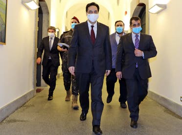 Lebanese Prime Minister Hassan Diab (C) walking while wearing a face mask ahead of an emergency cabinet session in Beirut on June 12, 2020. (AFP)