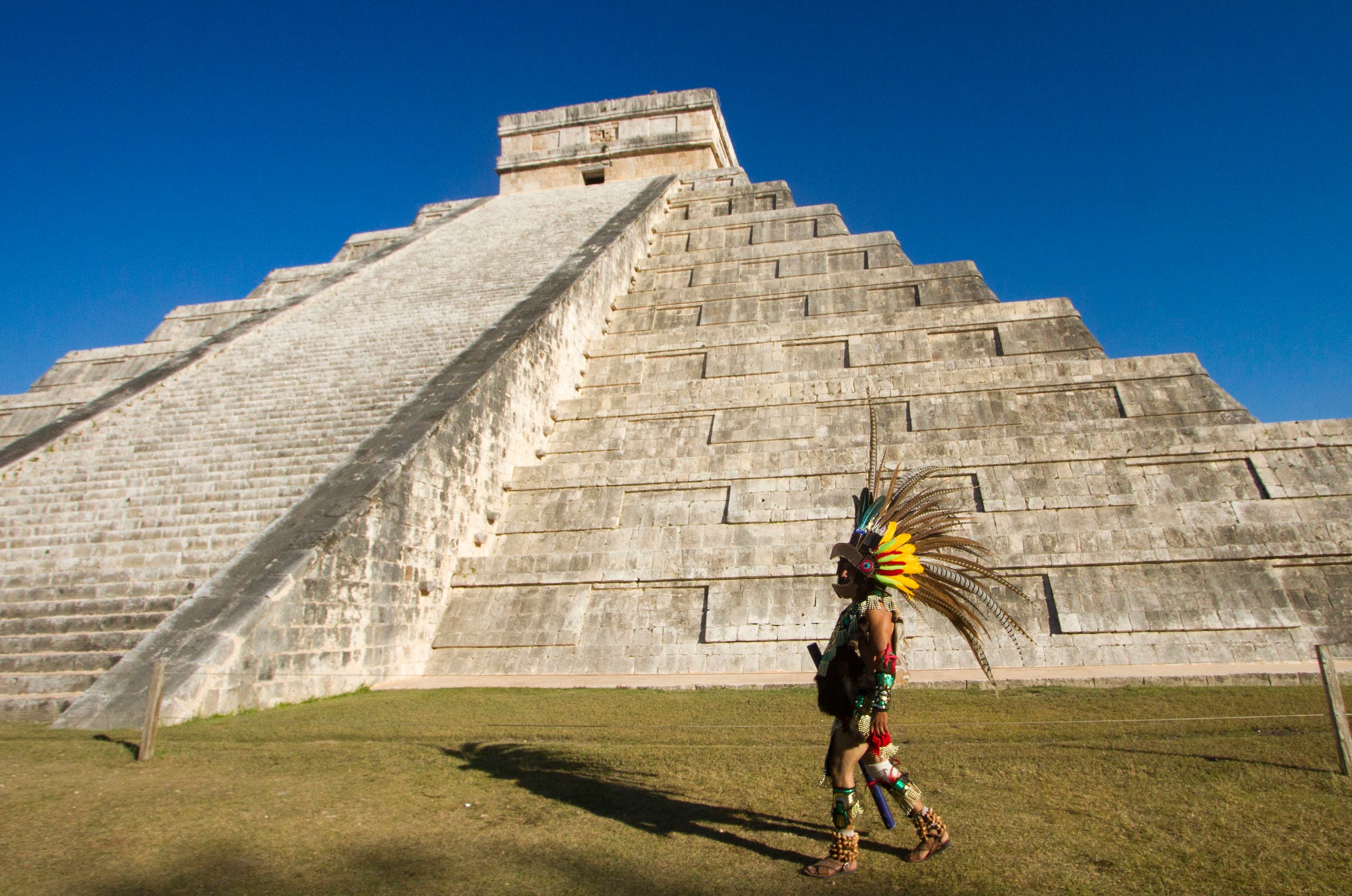 A Mexican man wearing a pre-hispanic costume walk next to the kukulkan pyramid at the Chichen Itza archaeological park, in Yucatan state, Mexico on December 20, 2012. (AFP)