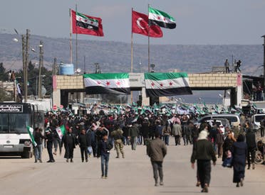 Internally displaced Syrians hold Syrian opposition flags during a protest in support of the Turkish army and Turkey backed Syrian rebels at the Bab el-Salam border crossing between the Syrian town of Azaz and the Turkish town of Kilis, in Syria, February 25, 2020. (Reuters)