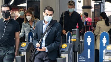 Commuters wearing face masks walk through the ticket barriers at Waterloo Station in London on June 15, 2020 after new rules make wearing face coverings on public transport compulsory while the UK further eases its coronavirus lockdown. (AFP)