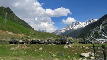 Indian army soldiers walk past their parked trucks at a makeshift transit camp before heading to Ladakh, near Baltal, southeast of Srinagar, June 16, 2020. (Reuters)