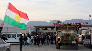 A man waves a Kurdistan flag as a Turkish military truck escorts a convoy of peshmerga vehicles at Habur border gate, which separates Turkey from Iraq, near the town of Silopi in southeastern Turkey, October 29, 2014. (Reuters)