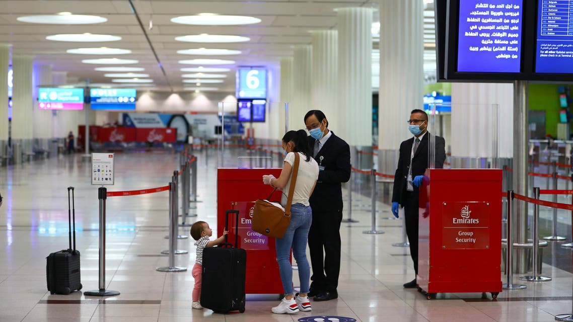 Emirates airline employees check a passenger at Dubai International Airport, as Emirates airline resumed limited outbound passenger flights amid outbreak of the coronavirus disease (COVID-19) in Dubai, UAE April 27, 2020. (Reuters)