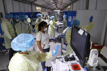 A woman waits to be tested by medical staff wearing protective equipment, amid the coronavirus outbreak, at a hospital in Abu Dhabi, UAE, April 20, 2020. (Reuters)