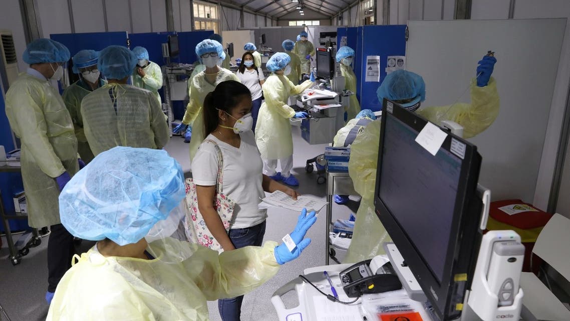 A woman waits to be tested by medical staff wearing protective equipment, amid the coronavirus outbreak, at a hospital in Abu Dhabi, UAE, April 20, 2020. (Reuters)