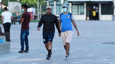Men walk along the Corniche waterfront promenade in the Qatari capital Doha on June 15, 2020, as the country gradually lifts its Covid-19 lockdown. (AFP)