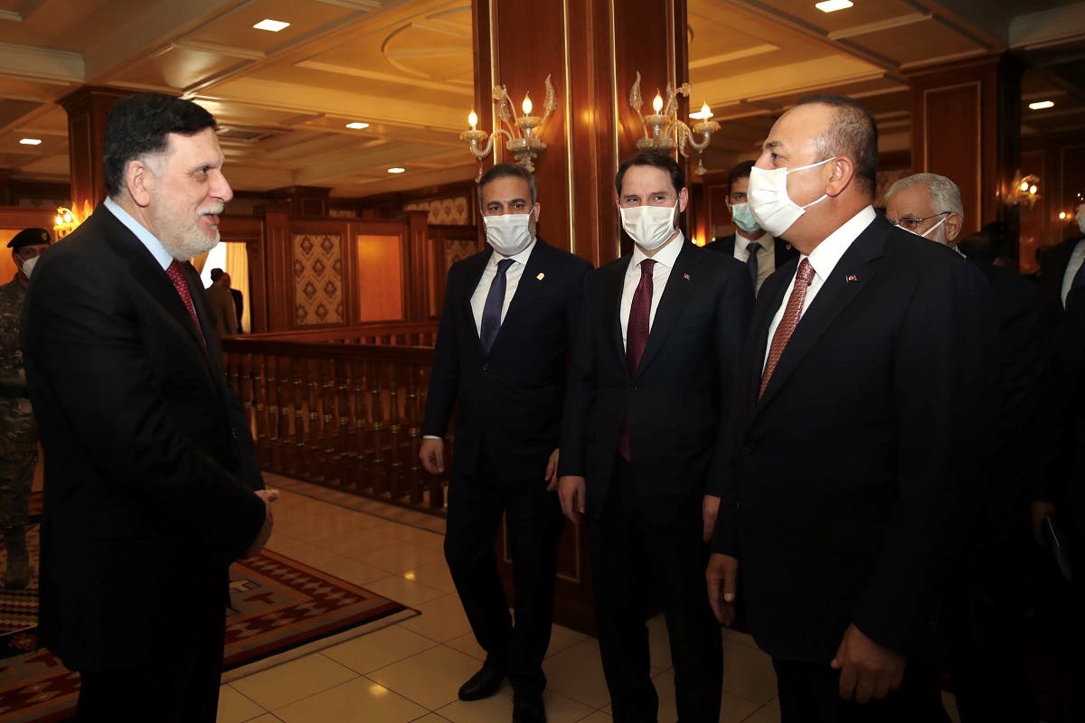 Turkish Foreign Minister Mevlut Cavusoglu (R) welcomed by Libyan Prime Minister Fayez al-Sarraj (L) prior to a meeting as part of their official visit to Libya on June 17, 2020. (AFP)