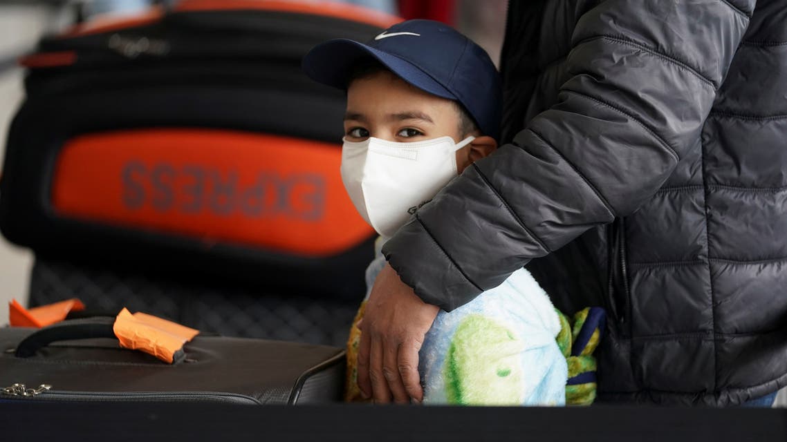 A boy wearing a face mask stands in the check-in line with his family at Dulles International Airport a day after U.S. President Donald Trump announced travel restrictions on flights from Europe to the United States for 30 days to try to contain coronavirus, in Dulles, Virginia, U.S., March 12, 2020. (Reuters)