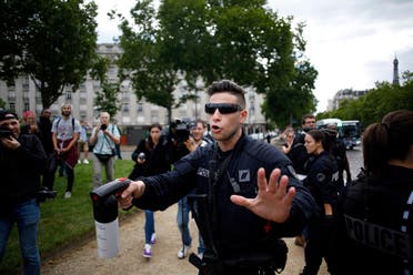 A police officer keeps people at a distance while anticolonial activist cover French military commander Joseph Gallieni statue with a black cloth, in Paris, Thursday, June 18, 2020. (AP)