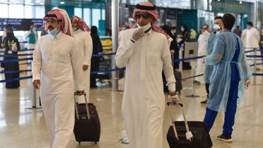 Saudi passengers queue for a temperature check at terminal 5 in the King Fahad International Airport, designated for domestic flights, in the capital Riyadh on May 31, 2020. (AFP)