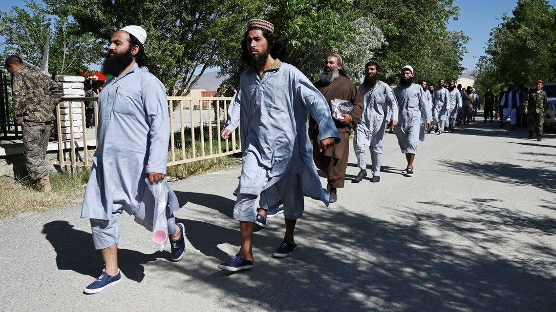 (FILES) In this file photo taken on May 26, 2020, Taliban prisoners walk in a line during their release from the Bagram prison, next to the US military base in Bagram. Afghan authorities are opening prison doors for thousands of Taliban inmates in a high-stakes gambit to ensure the insurgent group begin peace talks with Kabul.