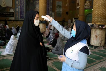 An Iranian woman wearing a protective face mask checks the temperature of a worshipper before attending the Friday prayers in Qarchak Jamee Mosque, following the outbreak of the coronavirus disease (COVID-19), in Tehran province, in Qarchak, Iran, June 12, 2020. (Reuters)