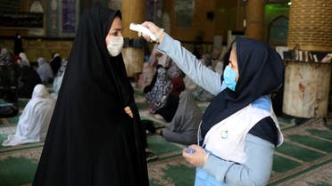 An Iranian woman wearing a protective face mask checks the temperature of a worshipper before attending the Friday prayers in Qarchak Jamee Mosque, following the outbreak of the coronavirus disease (COVID-19), in Tehran province, in Qarchak, Iran, June 12, 2020. WANA (West Asia News Agency)/Ali Khara via REUTERS ATTENTION EDITORS - THIS PICTURE WAS PROVIDED BY A THIRD PARTY
