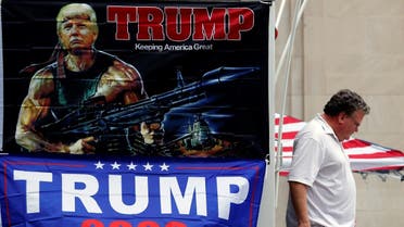 A man walks past banners of U.S. President Donald Trump sits on a roadblock near the BOK Center for his upcoming rally in Tulsa. (Reuters)