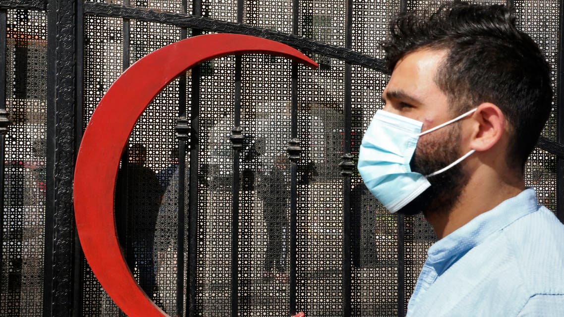 A mask-clad man stands outside the gate of a hospital of the Palestinian Red Crescent Society awaiting COVID-19 coronavirus testing in the village of Halhoul, north of Hebron in the occupied West Bank, on June 19, 2020, as the area registered a surge of new cases of COVID-19 coronavirus amidst the ongoing pandemic. 