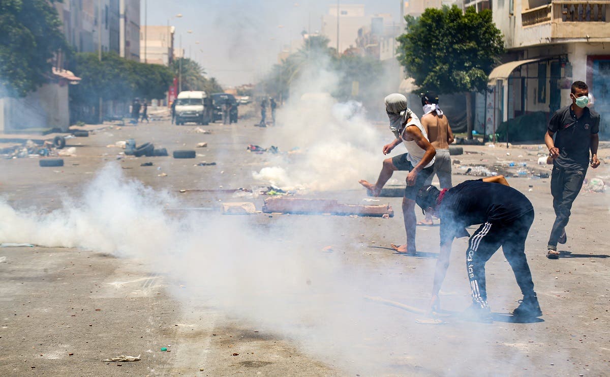 Protesters from Tunisia's Tataouine region throw stones as they clash with security forces, firing tear gas, amidst a demonstration in the southern city on June 21, 2020. (AFP)