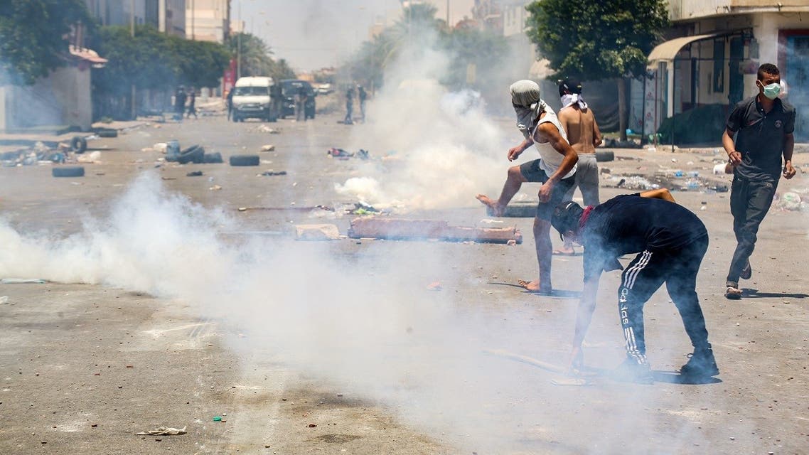 Protesters from Tunisia's Tataouine region throw stones as they clash with security forces, firing tear gas, amidst a demonstration in the southern city on June 21, 2020. (AFP)