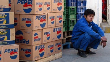 A PepsiCo worker watches over a delivery of the soft drinks to a supermarket in Beijing, 26 May 2003. (AFP)