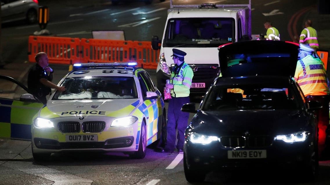 Police officers and their vehicles are seen at a cordon at the scene of reported multiple stabbings in Reading, Britain. (Reuters)