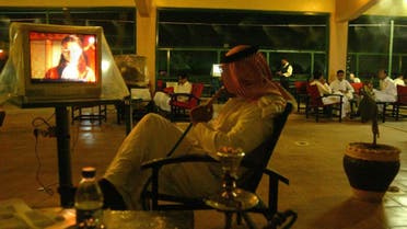 A Saudi citizen smokes a hookah (traditional waterpipe) while watching TV at a cafe in Riyadh, Saudi Arabia. (File photo: AFP)