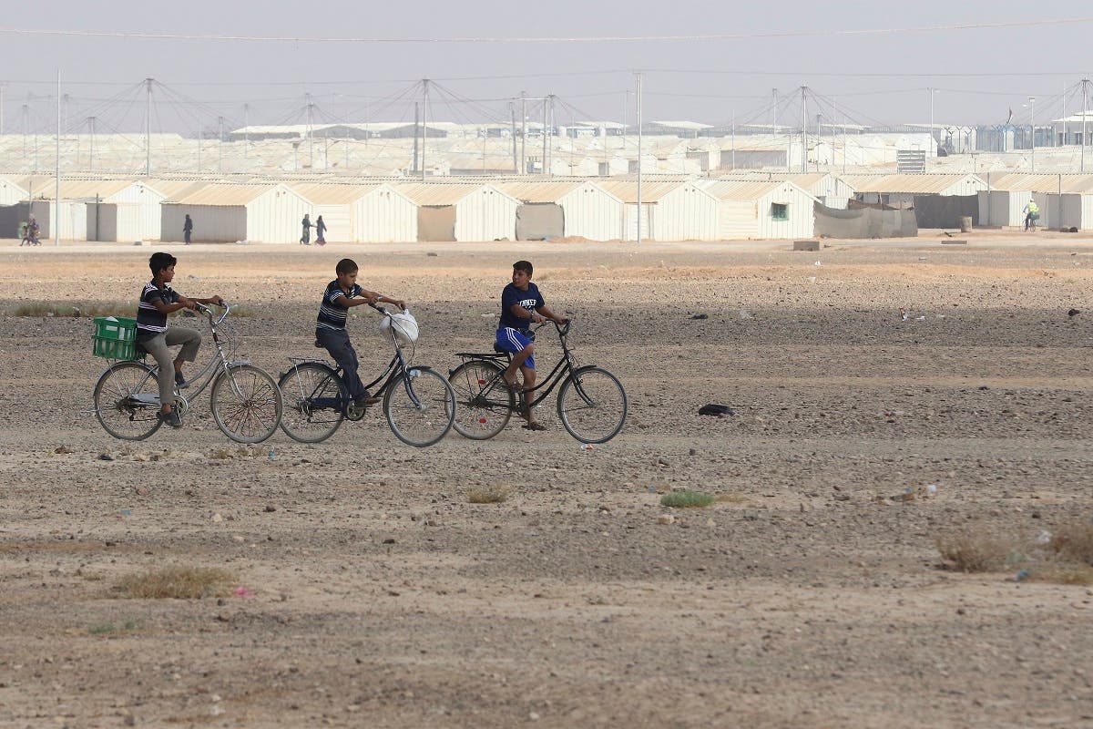 Young Syrian refugees ride their bicycles at the Azraq camp for Syrian refugees in northern Jordan on August 2, 2018. (AFP)