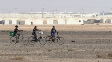 Young Syrian refugees ride their bicycles at the Azraq camp for Syrian refugees in northern Jordan on August 2, 2018. (AFP)