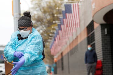 عاملة صحية ترتدي لباساً واقياً أمام أحد مستشفيات نيويورك