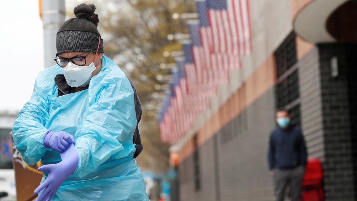 FILE PHOTO: An Emergency Medical Technician (EMT) dons personal protective equipment before going into Elmhurst Hospital during the ongoing outbreak of the coronavirus disease (COVID-19) in the Queens borough of New York, U.S., April 20, 2020. REUTERS/Lucas Jackson/File Photo
