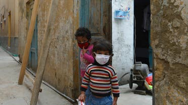 Children wearing facemasks play in front of their house during a government-imposed nationwide lockdown as a preventive measure against the COVID-19 coronavirus in Rawalpindi on March 30, 2020. (AFP)