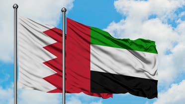 Bahrain and United Arab Emirates flag waving in the wind against white cloudy blue sky together. Diplomacy concept, international relations. stock photo