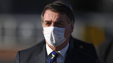In this file photo taken on May 12, 2020 Brazilian President Jair Bolsonaro wears a face mask as he arrives at the flag-raising ceremony before a ministerial meeting at the Alvorada Palace in Brasilia. (AFP)
