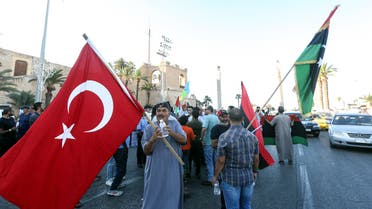 People wave flags of Libya (R) and Turkey (L) during a demonstration in the Martyrs' Square in the centre of the Libyan capital Tripoli, currently held by the UN-recognised Government of National Accord (GNA), on June 21, 2020. The GNA on June 21 denounced Egypt's warning of military intervention in Libya, labelling it a declaration of war, after the Egyptian President warned that if pro-GNA forces advanced on the strategic city of Sirte -- some 450 kilometres (280 miles) east of Tripoli -- it could provoke a direct intervention by Cairo.